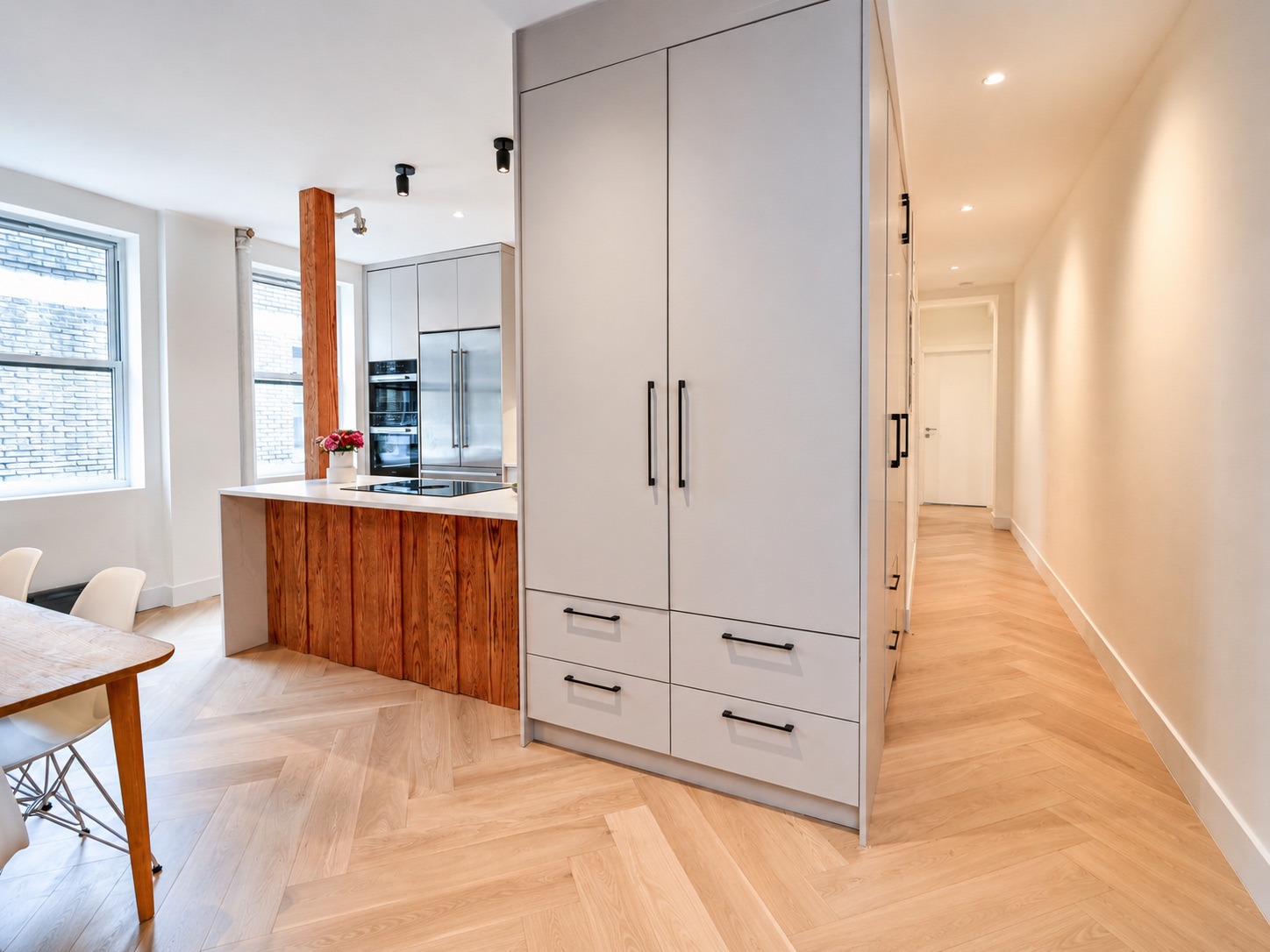 Open layout with white oak herringbone floors and hallway view